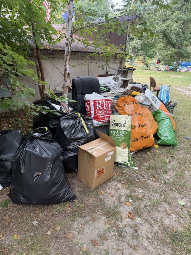 Bagged household junk, boxes and an old office chair ready to load